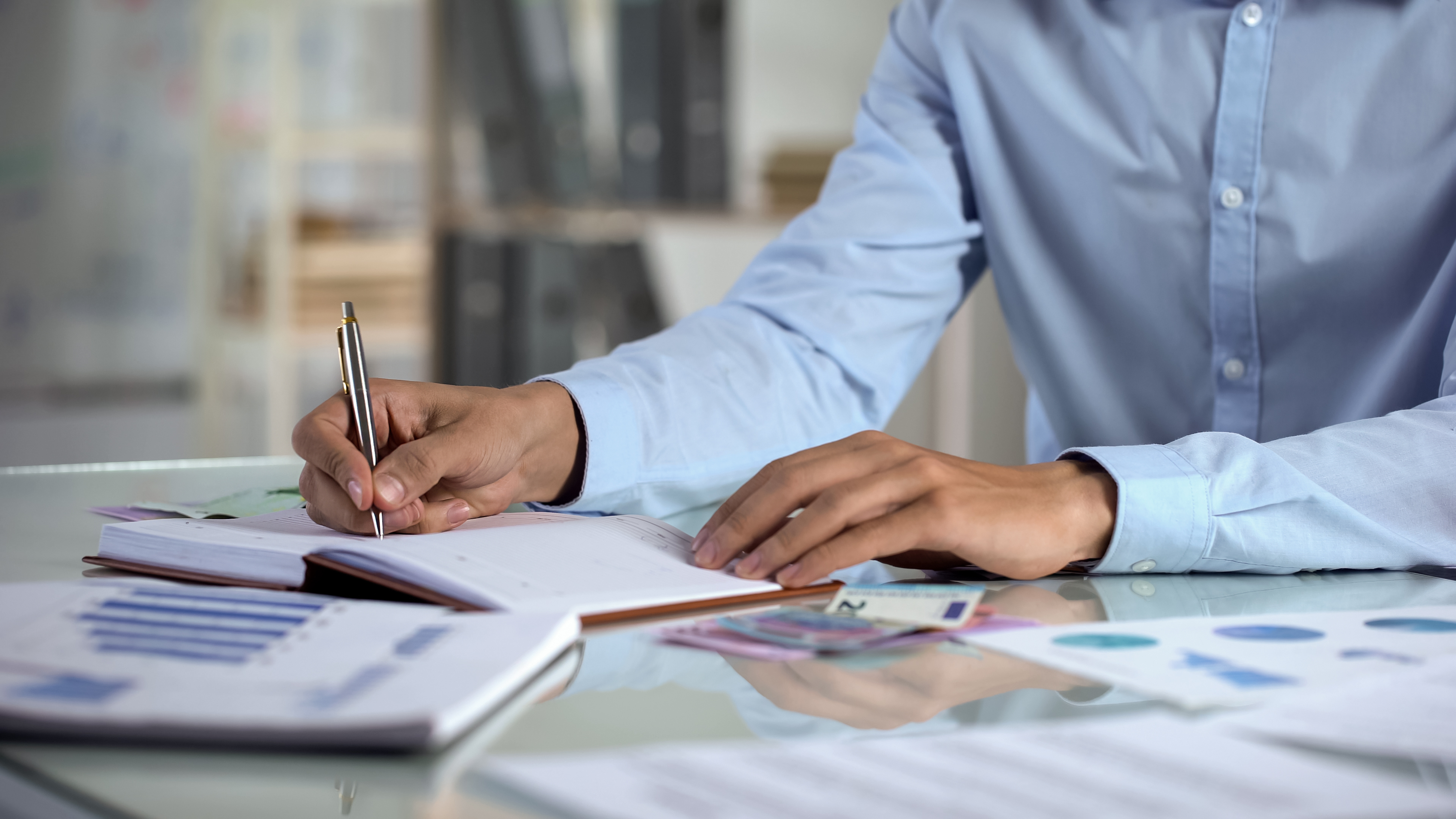 Picture of a man writing with a pen